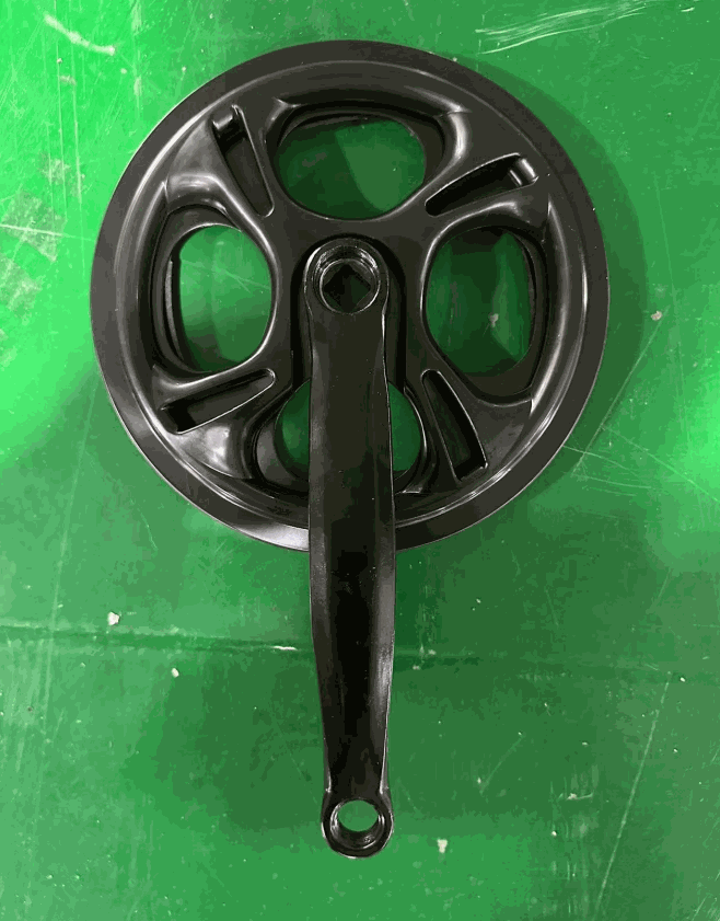 Sprocket with attached crank arm, black metal with smooth finish, circular design featuring five curved cutouts
