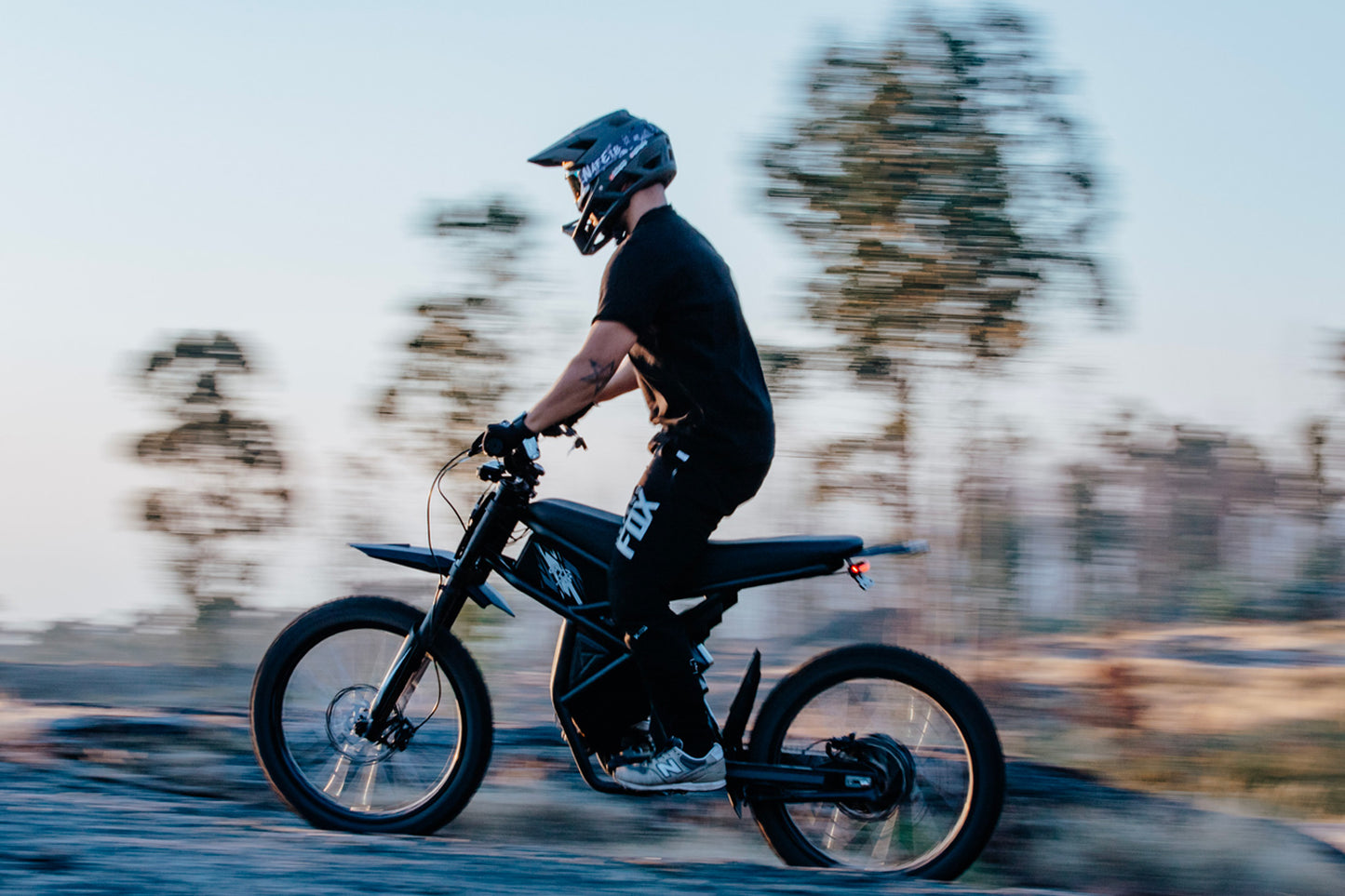 Person riding GT73 electric dirt bike with blurred background