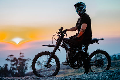 GT73 Electric Dirt Bike with rider at sunset - Off-road E-bike Performance