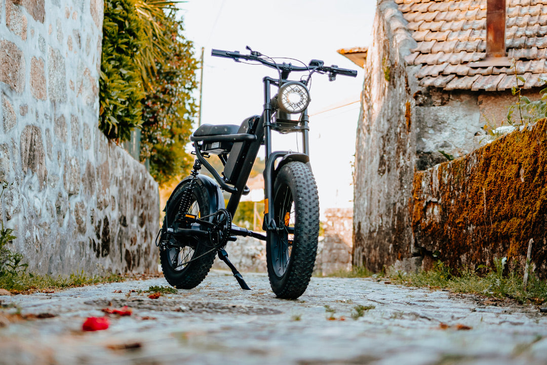 Black Z8 electric bike on a cobblestone street with stone walls and greenery.