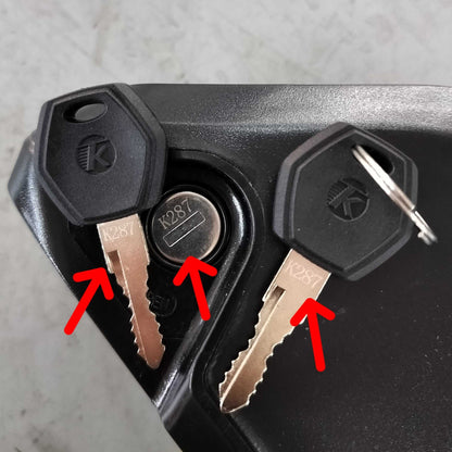 Battery Key pair with black plastic heads and metal blades marked K287, used for locking electric bike battery