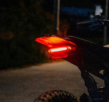 Brake Light on a black bicycle with a glowing red light at night showing its vibrant illumination