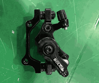 Disc Brake aluminum black mounted component with BOLIDS branding visible on the part against a green background